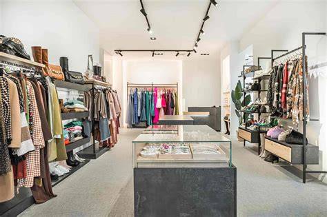Interno di un negozio di abbigliamento vintage con abiti colorati appesi alle pareti e scaffali pieni di oggetti.