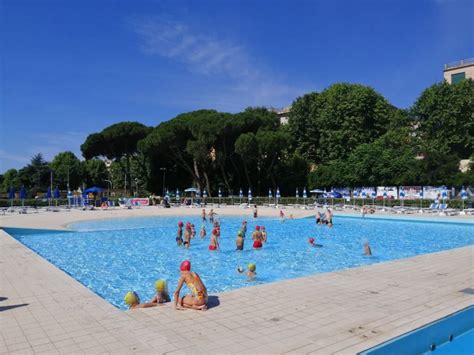 Piscina estiva attrezzata con ombrelloni e lettini in un club sportivo