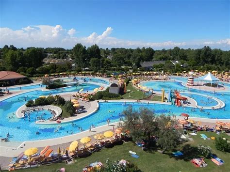 Piscina per famiglie con giochi d'acqua e aree relax in un villaggio turistico