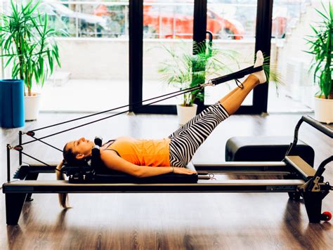Donna che esegue esercizi di Pilates su un Reformer