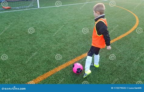 Giocatore di calcio giovane che corre con la palla