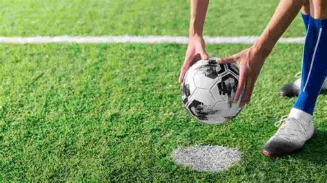 Un calciatore che esegue un rigore con una mossa acrobatica