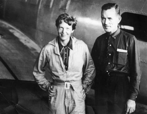 Amelia Earhart e il suo navigatore Fred Noonan mostrano una mappa del Pacifico di fronte al veivolo Electra