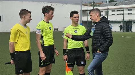 Romeo Giannoni sorridente mentre consegna divise a giovani arbitri