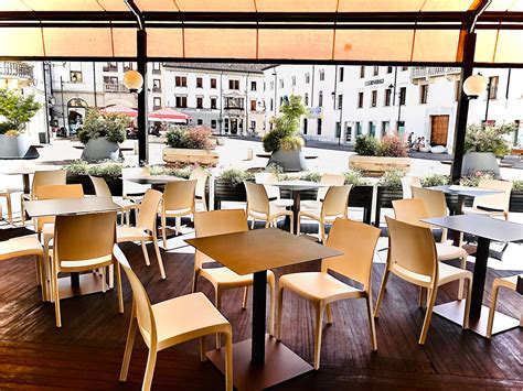 Interno di un bar accogliente con tavoli e persone che chiacchierano